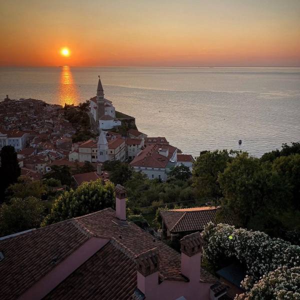 Stairway to serenity. ✨ Captivated by the enchanting blend of pastel hues painting the sky as the sun gracefully bids adieu, revealing Piran's ethereal charm and the endless expanse of the shimmering Adriatic Sea. . ✨ #ifeelsLOVEnia #mojaslovenija #piran #sloveniaoutdoor 

Photo by @nika_veronika_sv